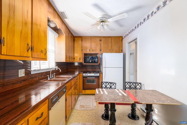 kitchen featuring decorative backsplash, ceiling fan, sink, and white appliances