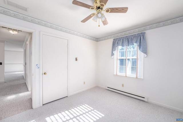 spare room featuring ceiling fan, light colored carpet, and a baseboard heating unit