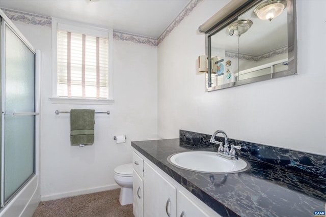 full bathroom with vanity, bath / shower combo with glass door, and toilet