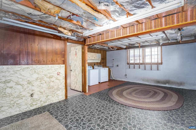 basement featuring washer and clothes dryer and wooden walls