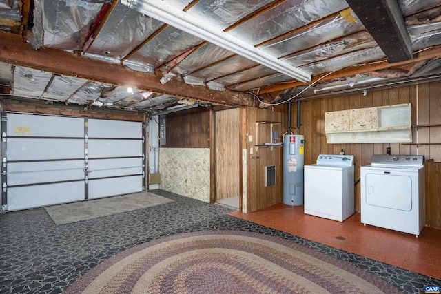 interior space featuring electric water heater, washer and clothes dryer, and wooden walls