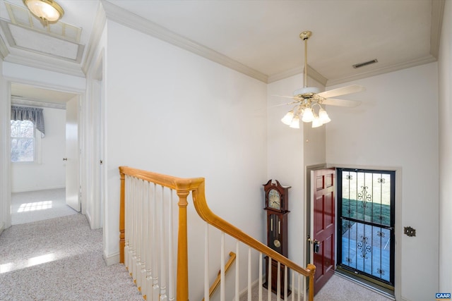 entrance foyer with carpet, ceiling fan, and crown molding