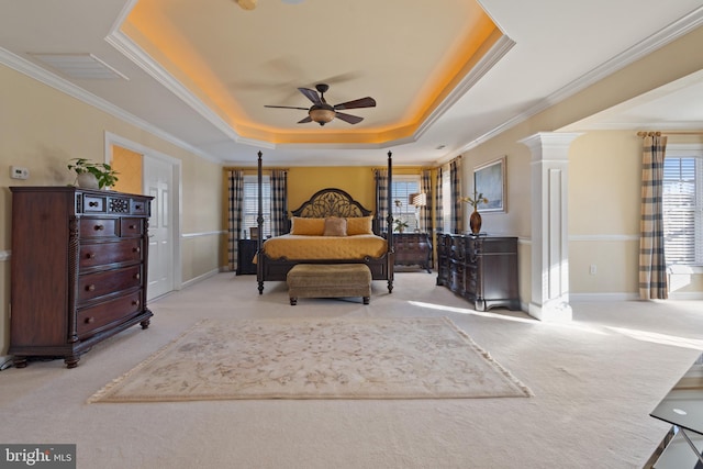 carpeted bedroom featuring a tray ceiling, ornate columns, and crown molding