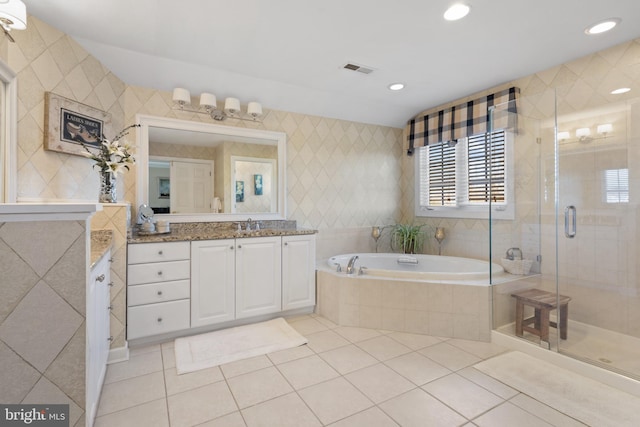 bathroom featuring shower with separate bathtub, vanity, and tile patterned floors