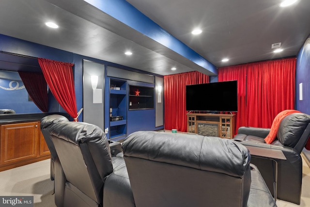 carpeted home theater featuring beamed ceiling