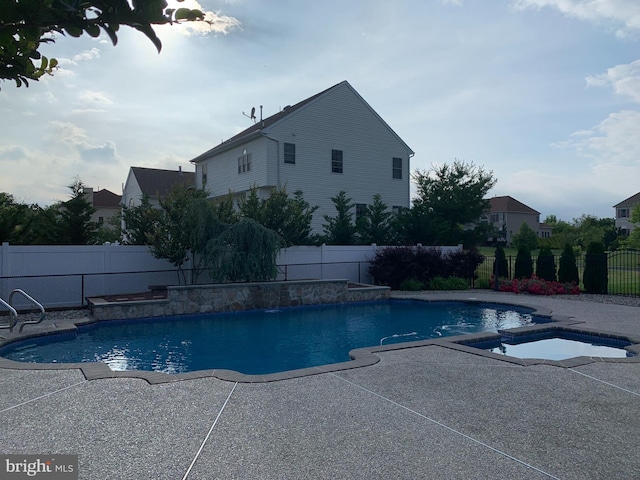 view of pool featuring a patio area and an in ground hot tub