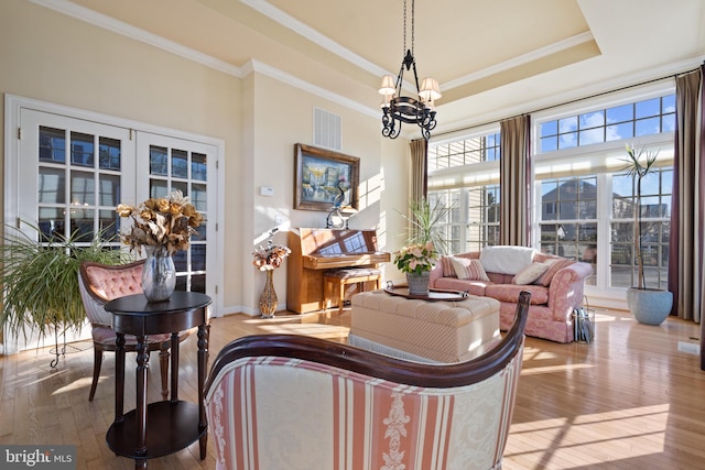 living room with light hardwood / wood-style flooring, a wealth of natural light, and ornamental molding