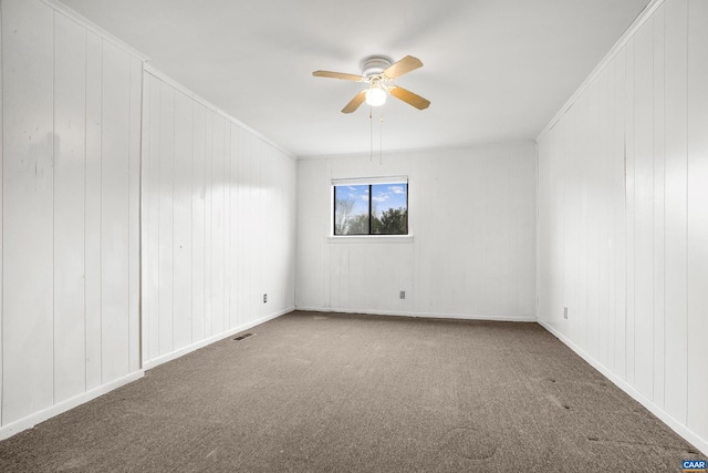 carpeted empty room with ceiling fan and crown molding