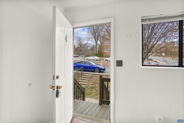 doorway to outside featuring crown molding and hardwood / wood-style flooring