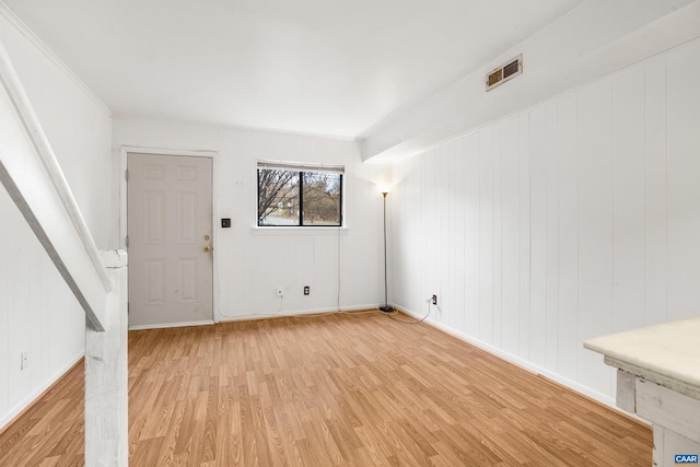 unfurnished room with light hardwood / wood-style floors and crown molding