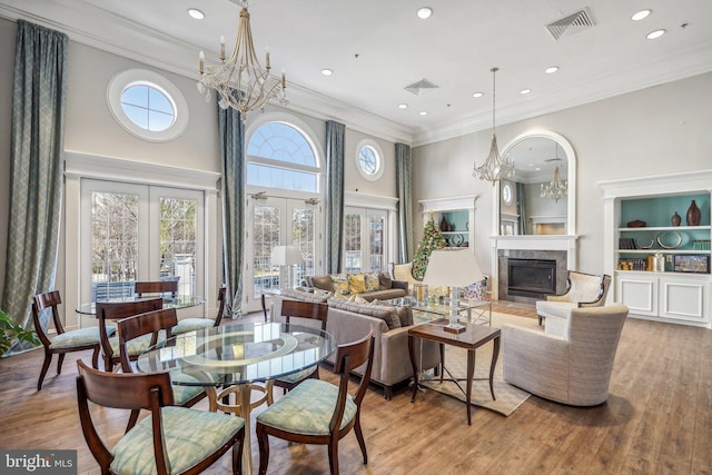 living room featuring a healthy amount of sunlight, wood-type flooring, and crown molding