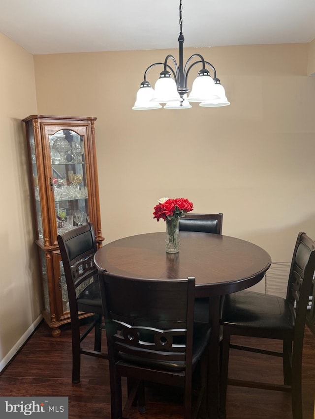 dining space featuring dark hardwood / wood-style floors and a notable chandelier