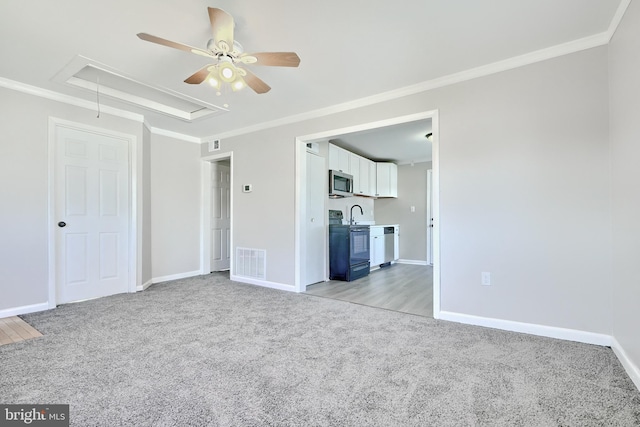 interior space with light carpet, a tray ceiling, ceiling fan, and ornamental molding