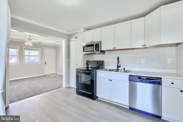 kitchen featuring appliances with stainless steel finishes, ceiling fan, sink, light hardwood / wood-style flooring, and white cabinetry