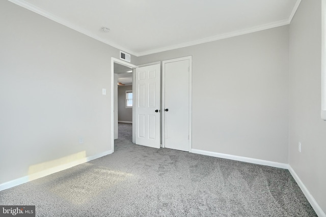 carpeted empty room featuring crown molding