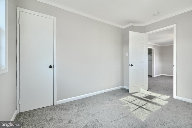 carpeted empty room featuring crown molding