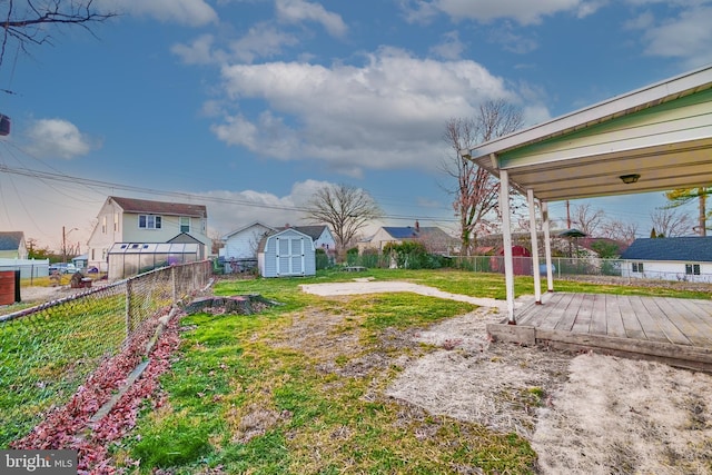 view of yard featuring a storage unit and a wooden deck