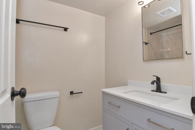 bathroom with a shower, vanity, and toilet