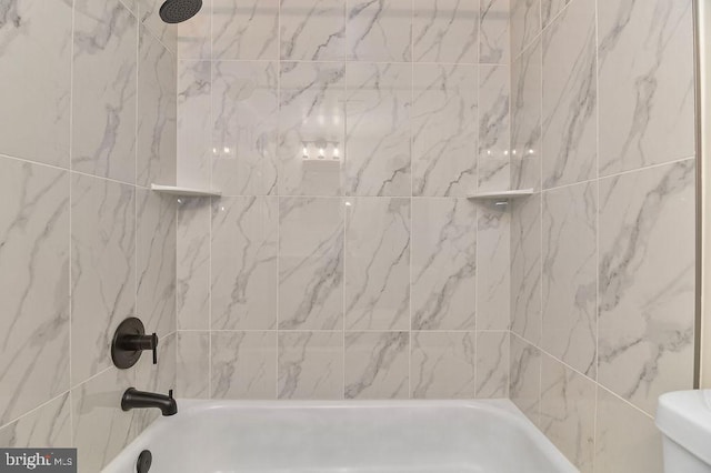 bathroom featuring toilet and tiled shower / bath