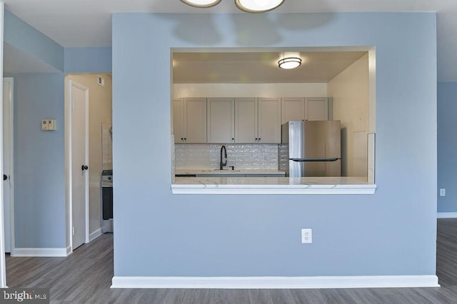 kitchen featuring backsplash, stainless steel fridge, sink, and dark wood-type flooring