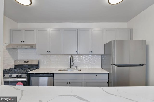 kitchen with decorative backsplash, gray cabinets, sink, and appliances with stainless steel finishes