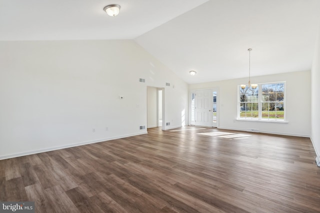 unfurnished living room featuring dark hardwood / wood-style floors, high vaulted ceiling, and a chandelier