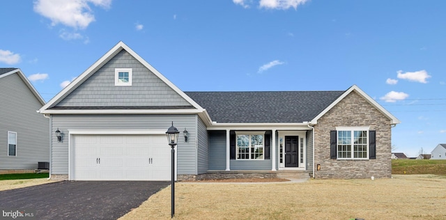 156 Ledger Dr Unit 75, Hanover, PA 17331 - view of front of house featuring stone siding, a garage, driveway, central air condition unit, and roof with shingles