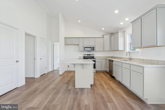 kitchen featuring gray cabinetry, stainless steel appliances, sink, light hardwood / wood-style floors, and a kitchen island