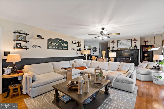 living room featuring light hardwood / wood-style flooring and ceiling fan