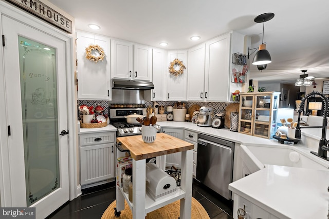 kitchen with dark tile patterned flooring, dishwasher, white cabinets, and hanging light fixtures