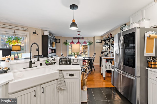 kitchen featuring white cabinets, stainless steel fridge, a wealth of natural light, and sink