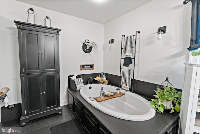 bathroom featuring a washtub, tile patterned floors, and sink