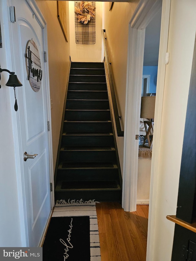 stairs featuring hardwood / wood-style flooring