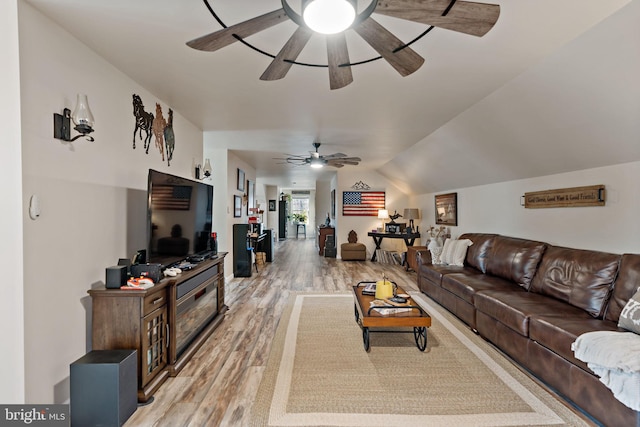 living room with light hardwood / wood-style flooring, ceiling fan, and lofted ceiling