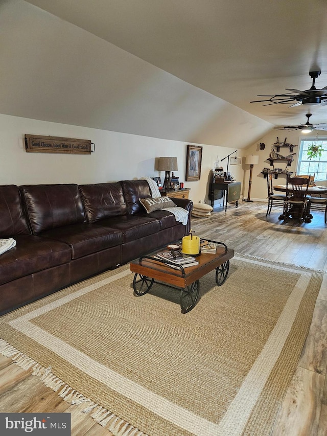 living room featuring ceiling fan, vaulted ceiling, and hardwood / wood-style flooring