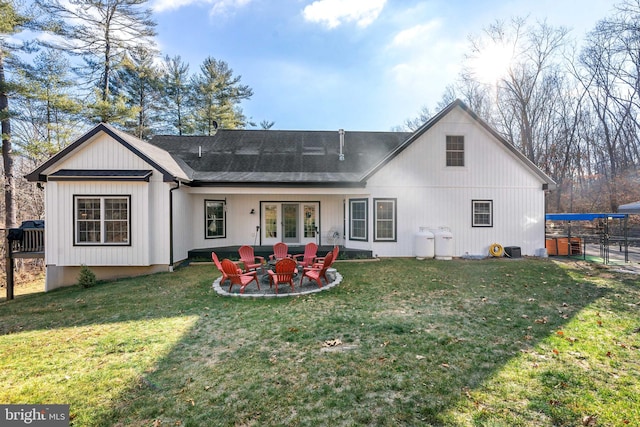 rear view of house with a lawn and a fire pit