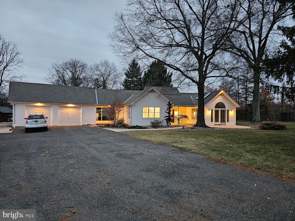 ranch-style home with a front lawn and a garage