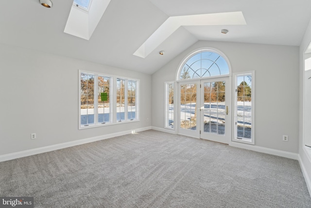 unfurnished living room with lofted ceiling with skylight and light colored carpet