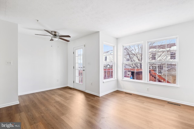 interior space with hardwood / wood-style flooring, a textured ceiling, and ceiling fan