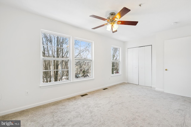 unfurnished bedroom with ceiling fan, a closet, and carpet