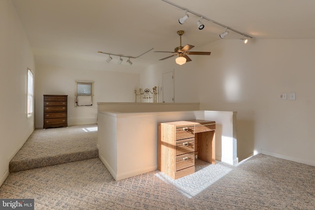 kitchen with ceiling fan, lofted ceiling, rail lighting, and light carpet