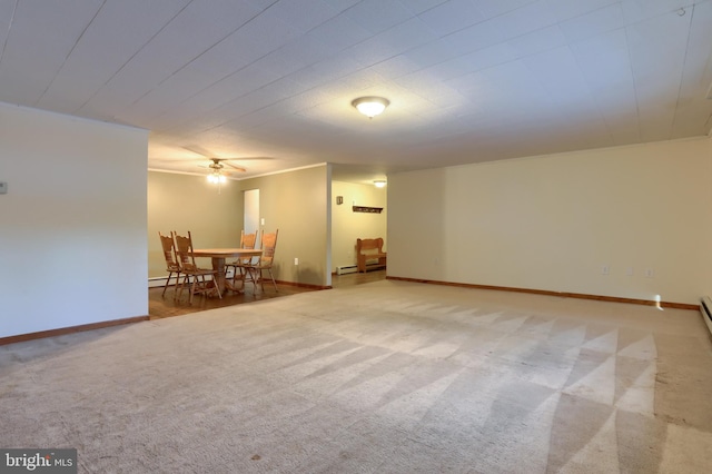 spare room with light colored carpet, a baseboard radiator, and ceiling fan