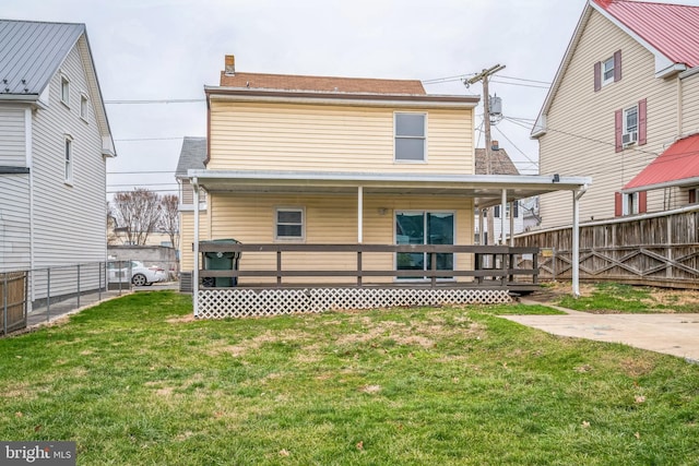 rear view of property featuring a lawn and a porch