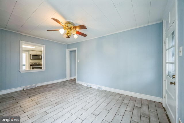 empty room featuring light wood-type flooring, ceiling fan, and crown molding