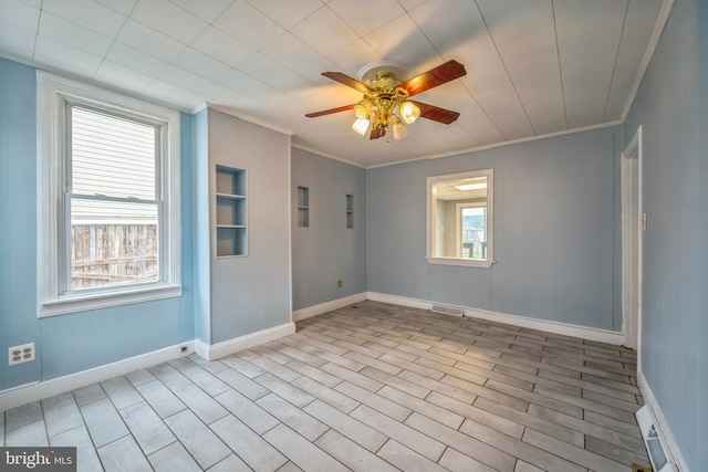 empty room with ceiling fan and ornamental molding