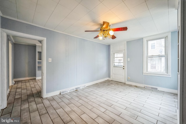 empty room featuring light hardwood / wood-style flooring, ceiling fan, and crown molding