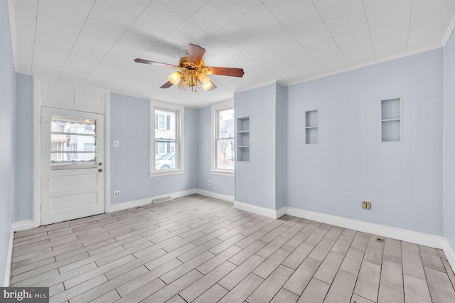 spare room featuring light hardwood / wood-style floors, ceiling fan, and crown molding