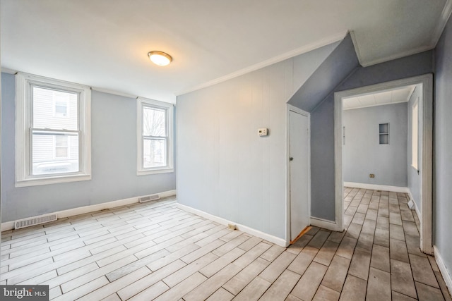 empty room with crown molding and light hardwood / wood-style floors