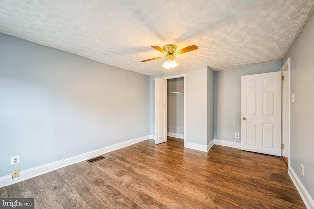 unfurnished bedroom with a closet, ceiling fan, hardwood / wood-style floors, and a textured ceiling