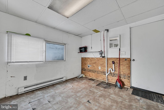 unfurnished room featuring a drop ceiling and baseboard heating